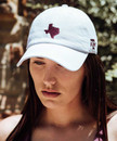 Texas A&M Aggies white baseball cap with maroon Texas state outline on front and small Texas A&M logo on side