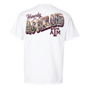 White Texas A&M T-shirt featuring a small Texas A&M College Station graphic on the left chest and a large back graphic with "Howdy" above colorful illustrated "Aggieland" lettering filled with Texas A&M traditions, campus landmarks, and College Station imagery.