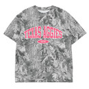 Texas Aggies camo t shirt with grayscale camouflage print, pink arched “Texas Aggies” lettering, and “1876” centered on the front