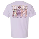 Lavender Texas A&M T-shirt featuring a small pastel front logo and oversized Texas A&M lettering on the back filled with gingham, floral, and colorful patchwork patterns.