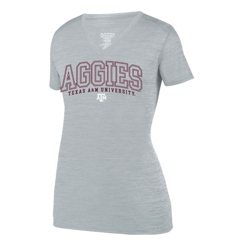 Arch "aggies" in block letters centered over "Texas A&M University" in maroon on the front of a short sleeve v-neck active shirt in silver.