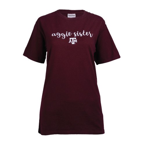 Maroon t-shirt with script font aggie sister centered over an ATM logo all embroidered in white across the center of the chest.