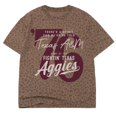 Brown Texas A&M T-shirt featuring an all-over tonal leopard print with oversized maroon 76 graphics, script Texas A&M and Aggies lettering, and traditional Aggie phrases.
