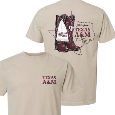 Natural cream Texas A&M T-shirt featuring maroon front lettering and a western back graphic with cowboy boots, Texas outline, 12th Man details, and “She’s from Texas A&M” text.