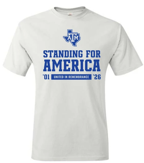 white Texas A&M T-shirt featuring a Texas A&M logo, bold “Standing for America” lettering, ’01 and ’26 dates, and “United in Remembrance” text on the front.
