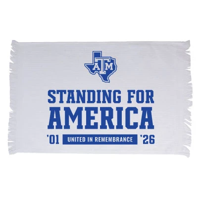 White Texas A&M game rally towel featuring blue Standing for America lettering, a Texas A&M logo inside a Texas outline, ’01 United in Remembrance ’26 details, and fringed edges.