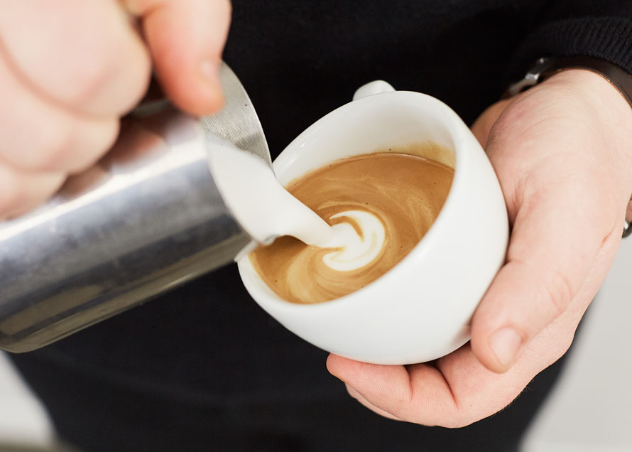 Pouring a dot in a white ceramic cup