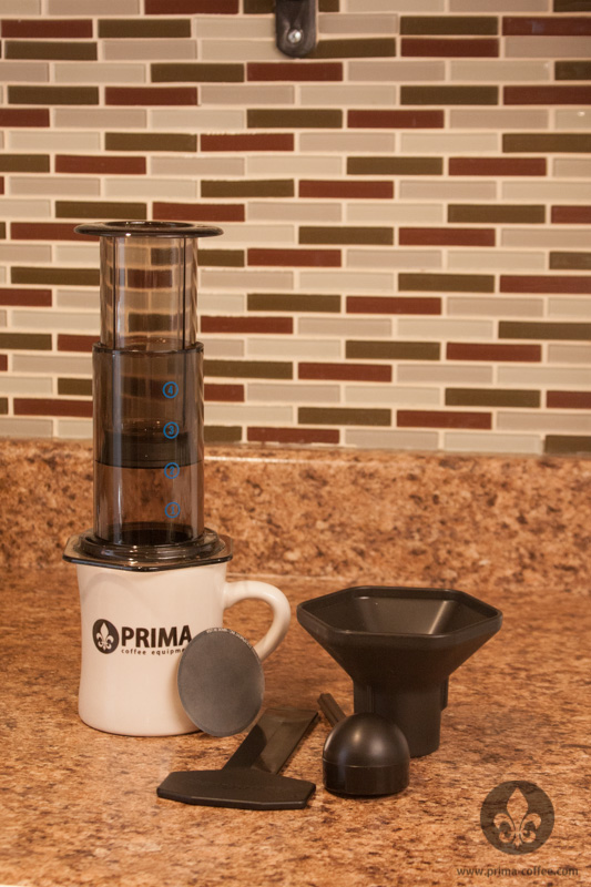 The Aeropress Coffee Maker and accessories Aeropress Coffee Maker with accessories and a Prima Coffee diner mug