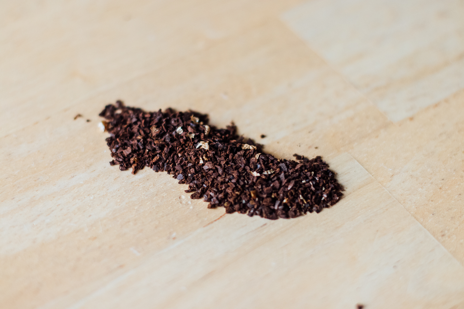 Sea salt-sized coffee grounds on a table, representing the appropriate grind size for brewing with the Chemex.