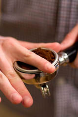 Distribute ground coffee evenly in your portafilter. Evenly distributed ground coffee in a portafilter.