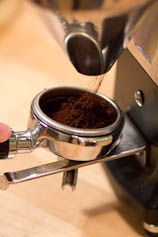 Grind and dose coffee into portafilter Coffee being dosed into a portafilter.
