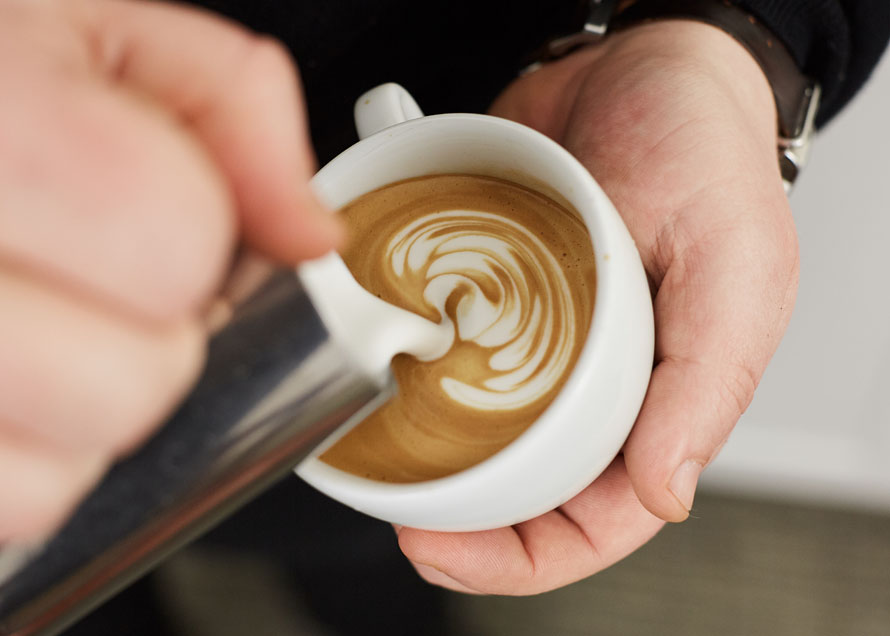 Stacks of latte art wiggles in a white cup