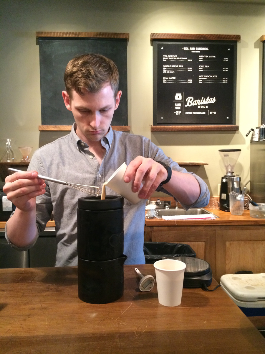 Handsome man pouring a latte into the Coil.