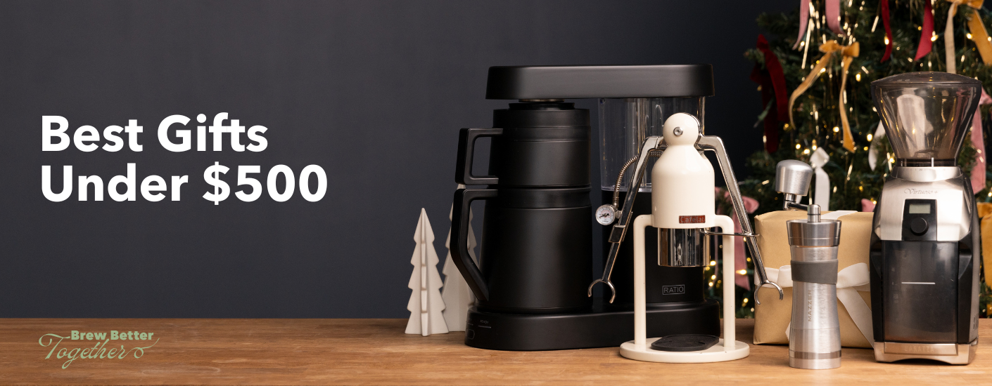 The Fellow Aiden coffee brewer, Cafelat Robot, Mazzer Omega hand grinder, and Baratza Vario electric grinder are sitting on a counter with holiday decorations.