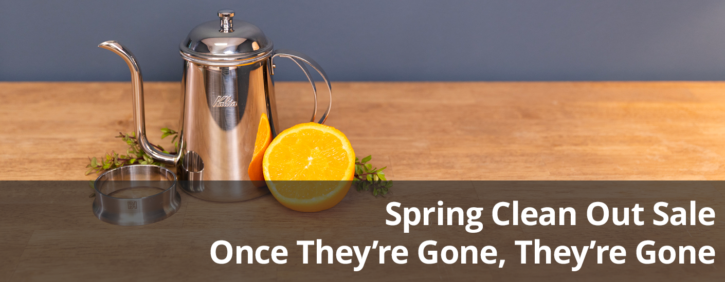 Coffee being poured into red painted Ancap cup with a jar of honey next to it.