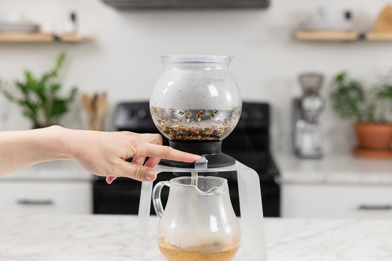 Finger Pressing the switch on the Hario Largo Tea Dripper