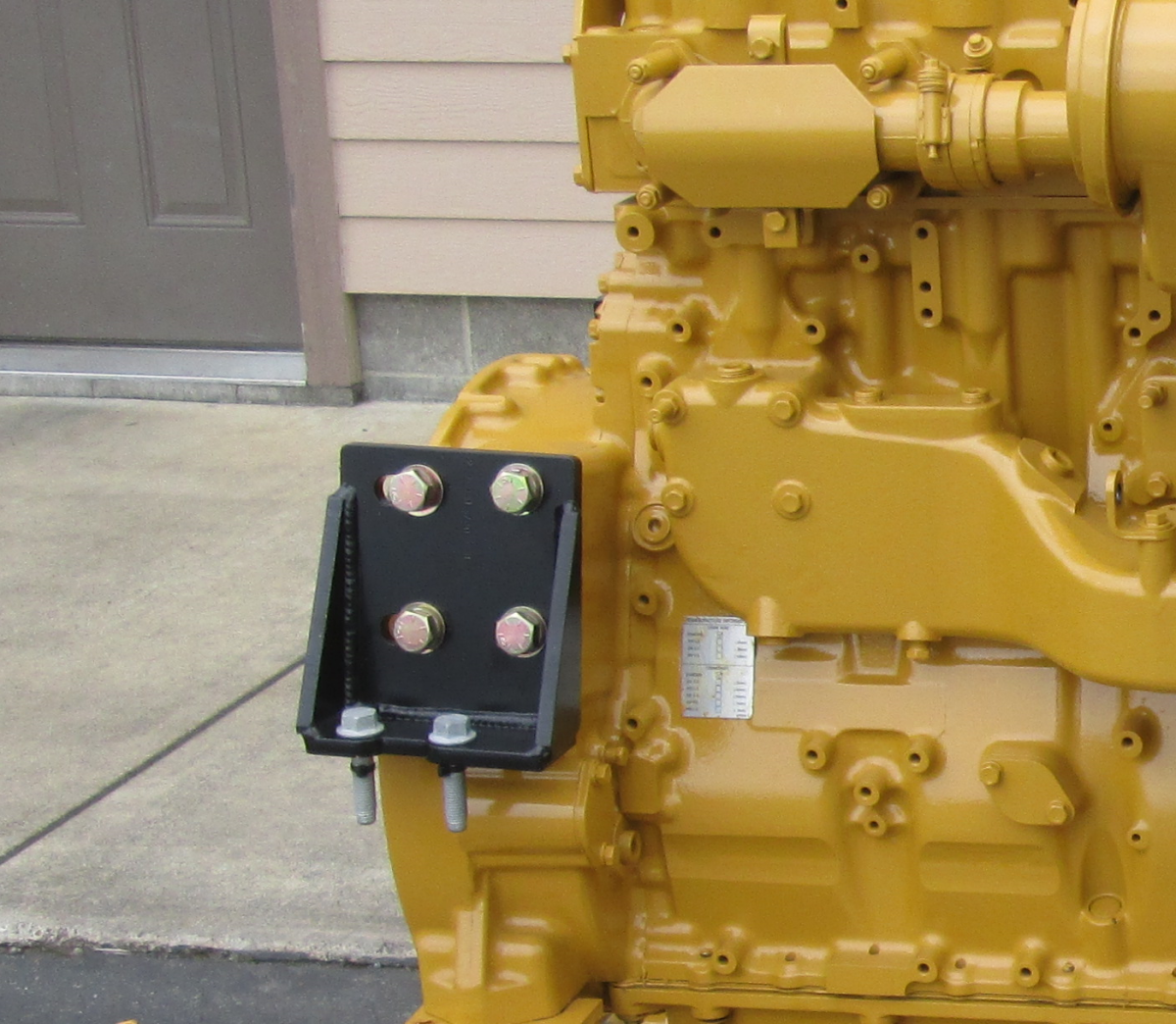 Caterpillar rear engine mounting bracket assembly showing bolt-down attachment points and Grade 8 hardware for chassis conversion