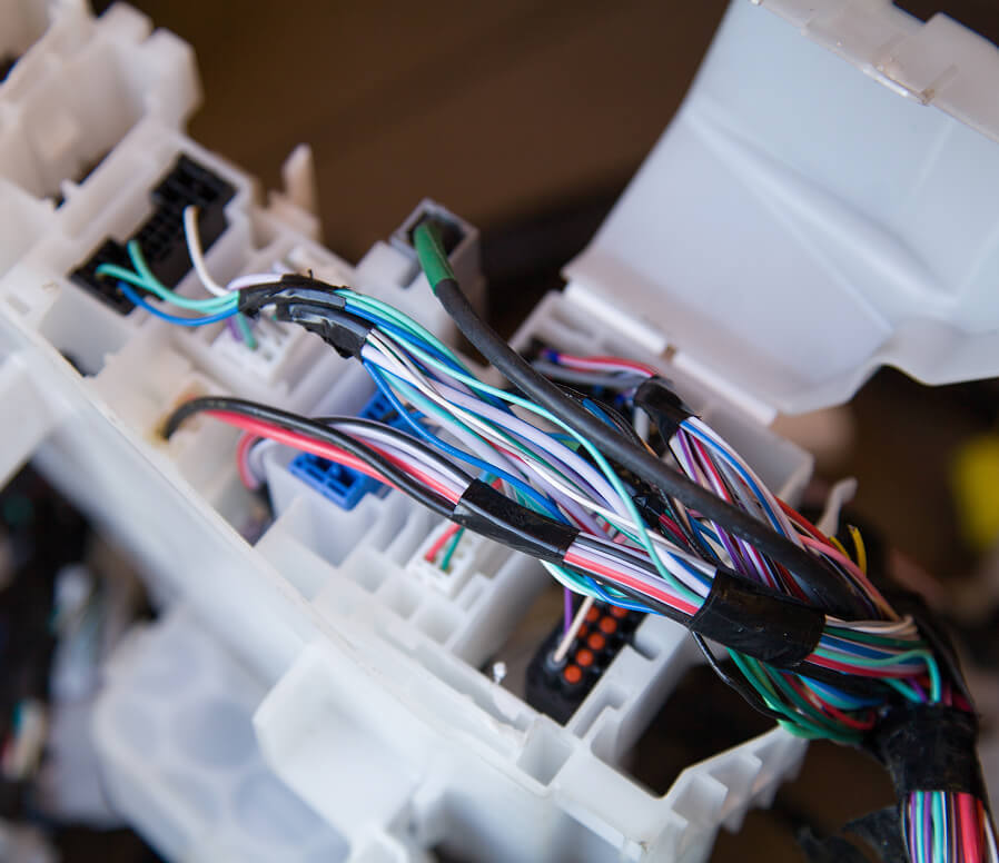 Close-up of engine wiring harness connectors and multi-wire loom during a truck ECM integration