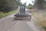 Grading a driveway with the skid steer box grader attachment.