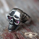 old wooden plank with a badass skull ring with blood red ruby eyes