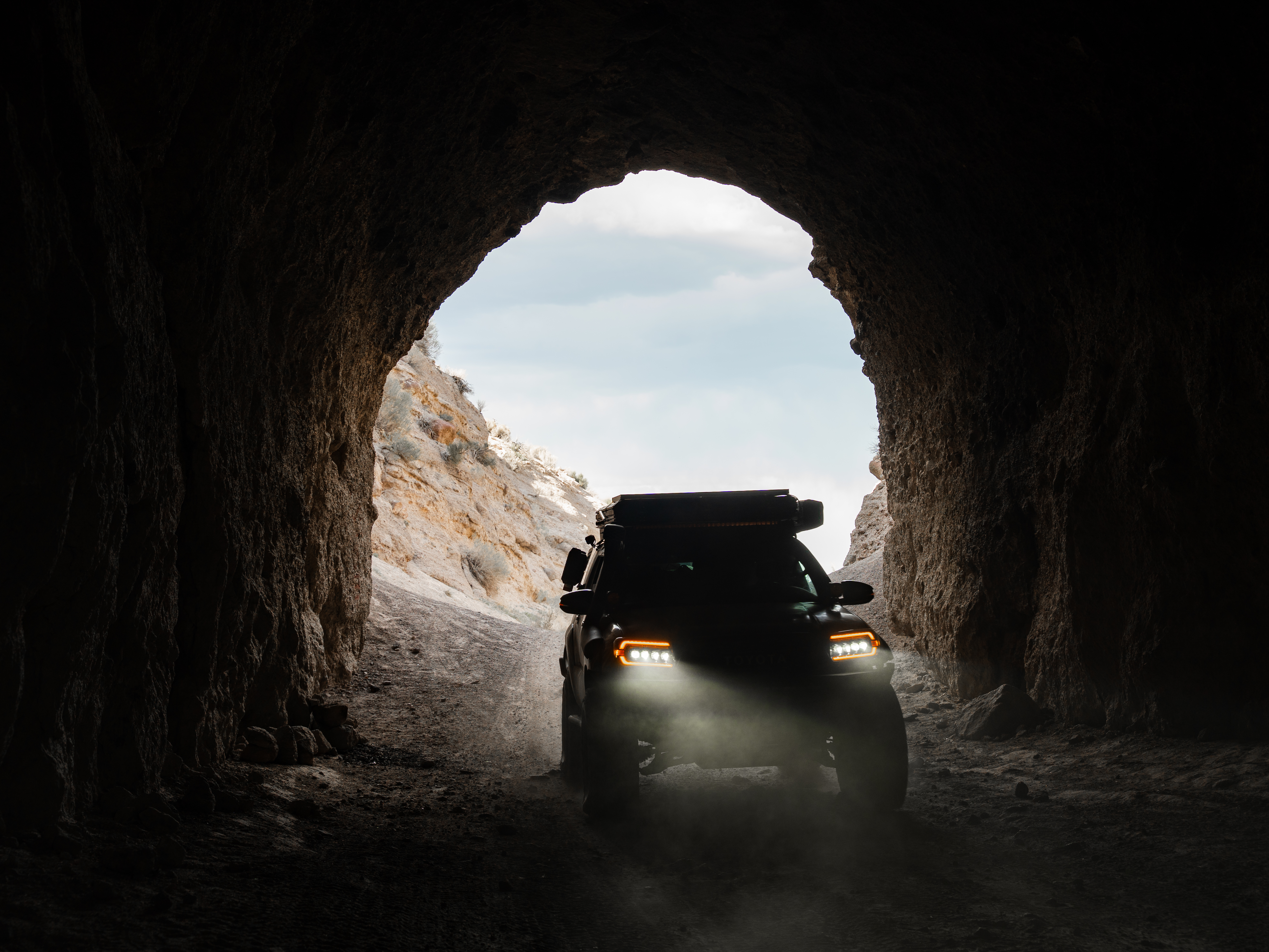Toyota 4Runner with amber off-road lighting inside a desert cave during the 4R Customs Memorial Day Sale