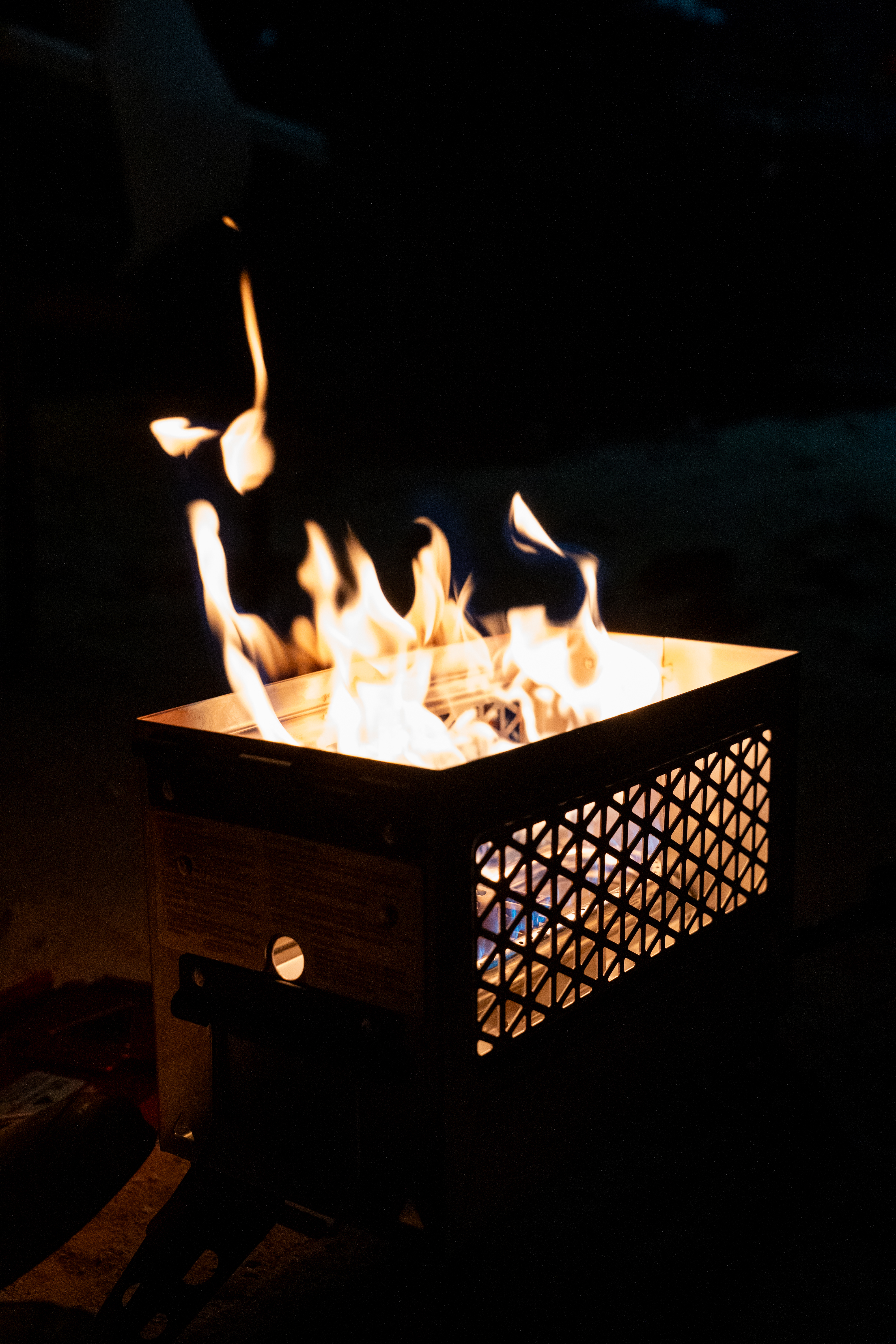 Propane fire can glowing at night beside a 4Runner camp setup