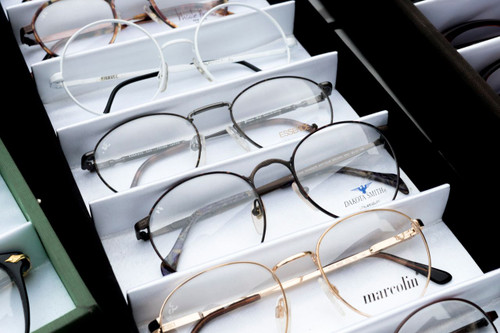 Display tray of assorted wire-rim eyeglass frames in white fabric slots