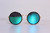 Round gold-and-black sunglasses with teal mirrored lenses on a white background