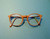 Round wood-grain eyeglass frames with clear lenses on a teal background
