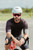 Cyclist in a white helmet wearing red-lens shield sunglasses on a road bike