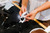 Person wiping a pair of white sunglasses with a cleaning cloth at an optical counter
