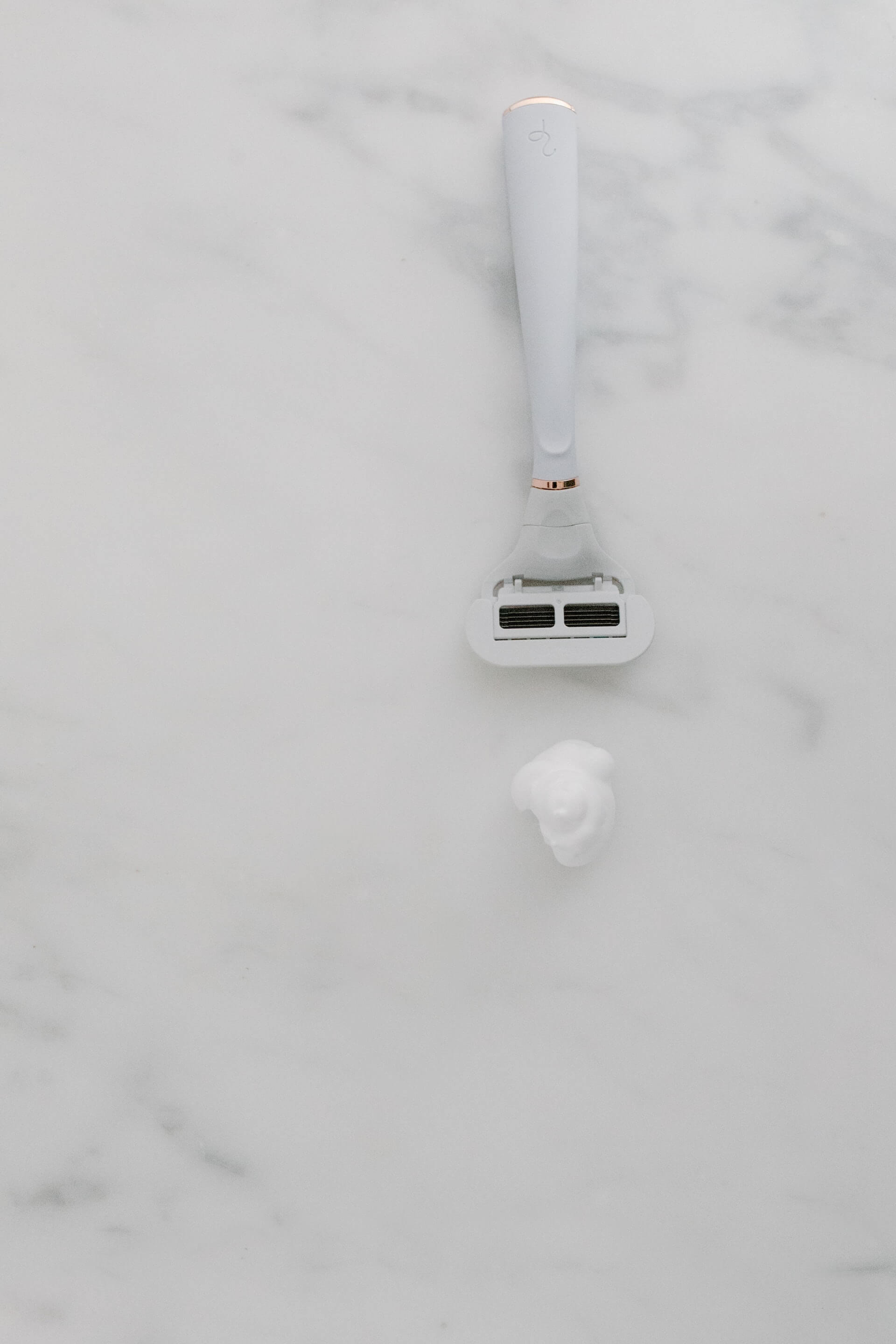 razor and dollop of shaving cream on table