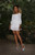 Full-length view of Robyn Ryan wearing the White Swiss Dot Mini Dress. The silhouette moves naturally with the body, emphasizing the lightweight fabric, mini length, and relaxed yet polished fit. Photography by Denise Greer Photography.