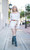 Lifestyle street image featuring model Hope wearing the White Off-Shoulder Swiss Dot Mini Dress in downtown Davenport. The contrast between soft, romantic fabric and urban surroundings creates a modern, wearable everyday elegance. Photography by Matt Vince.