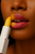 Close-up of lips wearing Pineapple Pop™ pH-Vibes™ Lipstick in fully revealed tropical pink shade on dark skin