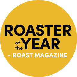 Yellow Circle with text says 'Roaster of the Year - Roast Magazine. Links to Roast Magazine Blog Post'