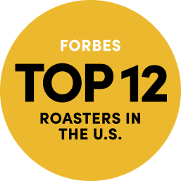 Yellow Circle with text says 'Forbes Top 12 Roasters in the U.S. Links to Forbes article about top 12 Roasters in U.S.'