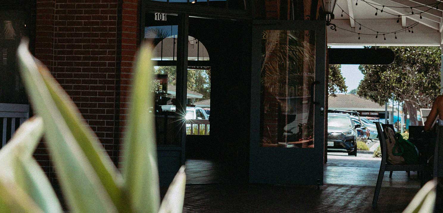 The front of the Encinitas cafe, showing two open doors and a rustic looking patio.