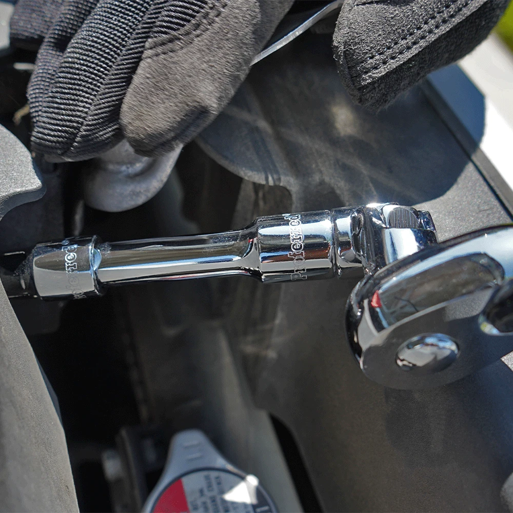 Proferred 3/8" Drive ratchet with extension bar and socket being used for automotive engine maintenance