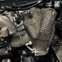Custom fabricated stainless exhaust heat shield installed around pipework in an mx-5 engine bay