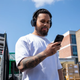 Man outdoors with phone and headphones