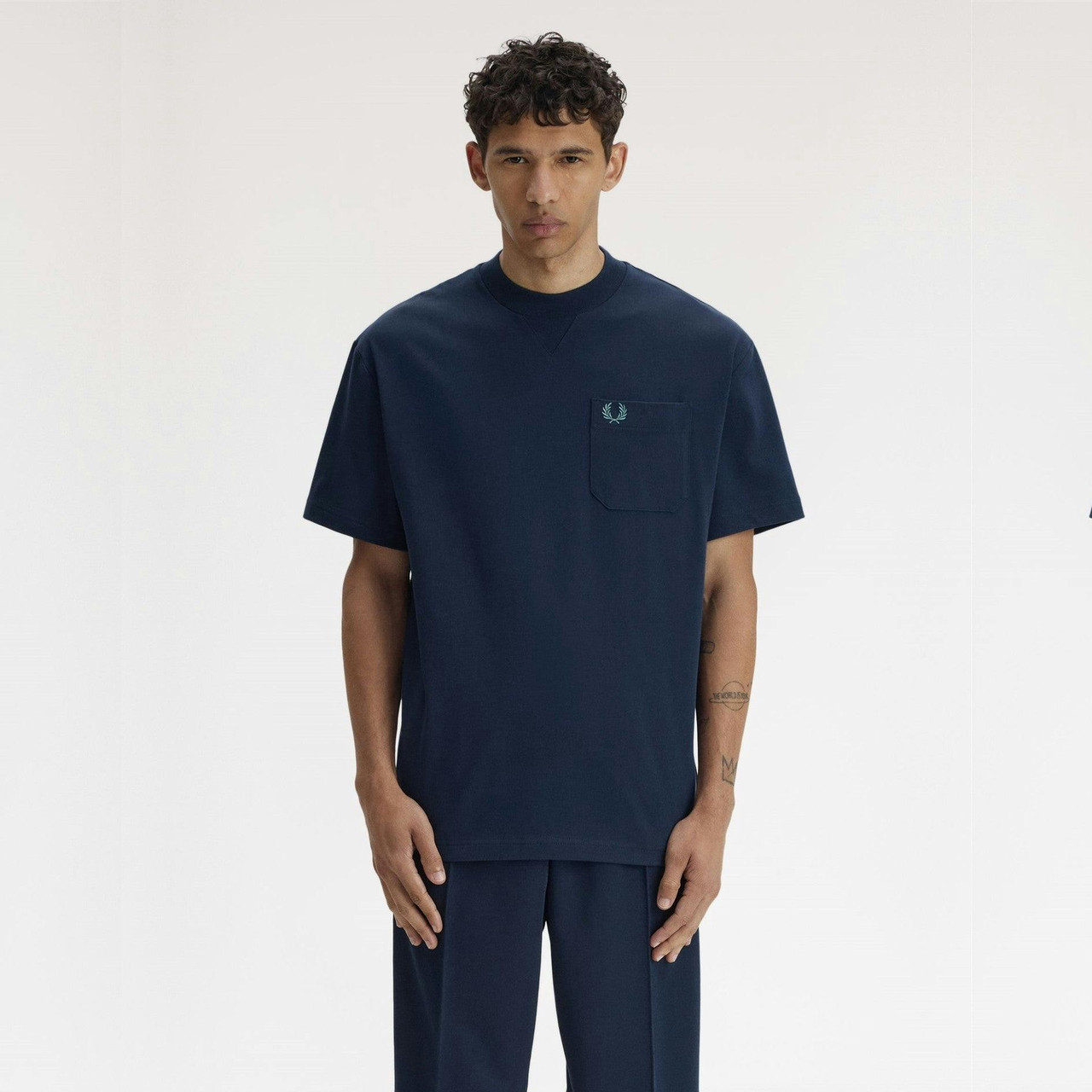 T-shirt com bolso detalhe bordado coroa de louros corte folgado