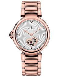 Relógio automático LaPassion Open Heart da Edox Swiss com vidro de safira, caixa e bracelete em aço inoxidável com acabamento rosé gold e mostrador prateado. Resistência à água: 5 ATM. Fecho de implantação. Inclui caixa, documentação e garantia de 3 anos. Marca: Edox Swiss.