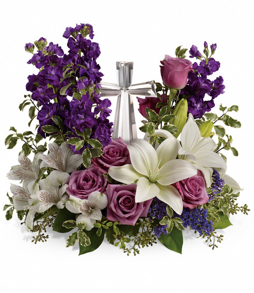 Purple and Lavender Flowers with Crystal Cross Keepsake from Sympathy Flower Shop. This sympathy bouquet includes lavender roses, white oriental lilies, white alstroemeria, purple stock and purple seafoam statice are arranged with fresh pitta, seeded eucalyptus and lemon leaf. Delivered with the small Crystal Cross keepsake, cross is approximately 7"H x 4"W x 1.5"D. Sympathy flowers are approximately 16" W x 14" H
SKU SYM471