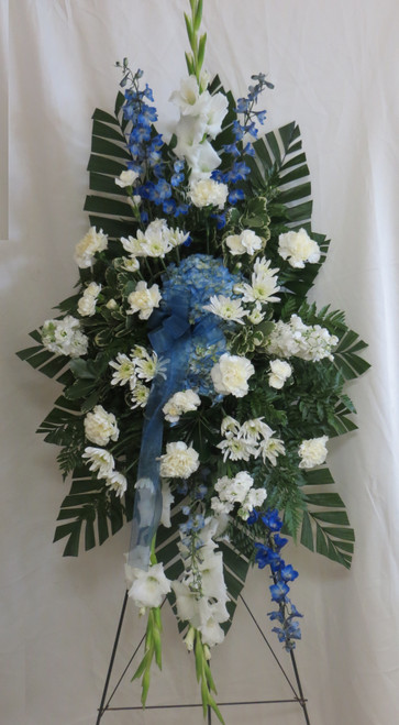 Sapphire Blue & White Funeral Spray from Enchanted Florist.  Our beautiful blue and white sympathy standing spray of flowers.  It includes blue delphinium, blue hydrangeas, white carnations and white stock with accent foliages. Approximately 70"H x 36"W size not including stand.
SKU RM547