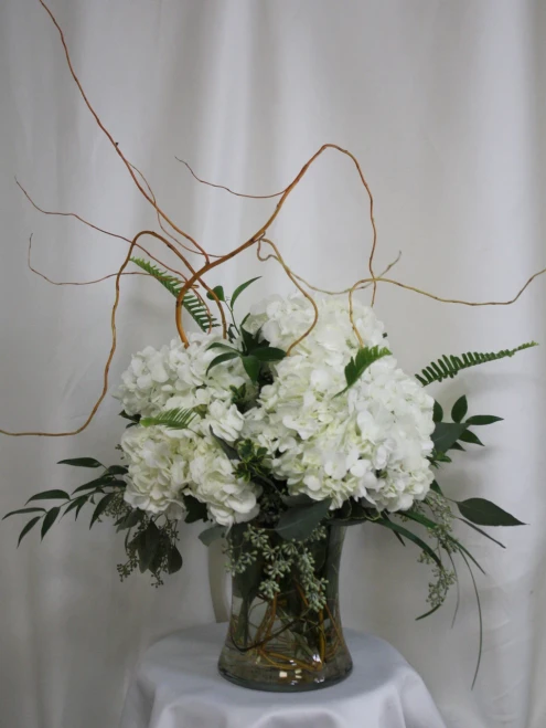 The Chloe White Hydrangea and Greenery Bouquet from Enchanted Florist. This beautiful and simple arrangement includes all white hydrangeas in a clear vase that is accented with several types of classic greeneries and curly willow.
Approximately 20"H x 18"W
SKU RM131