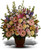 Her Loving Grace by Sympathy Flower Shop. This beautiful bouquet of blossoms includes pink, peach, and lavender flowers of roses, gerbera daisies, lilies, spray roses, alstromeria, lisianthus and larkspur in a traditional funeral urn. From our Houston funeral florist. SKU SYM408 