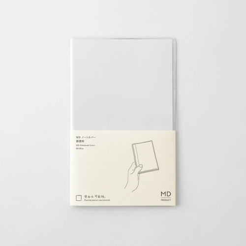 MIDORI MD Notebook Clear Cover B6 Slim edition. A transparent, flexible plastic notebook sleeve featuring a built-in pen loop on the interior back flap, fitted over a minimalist cream notebook. / Protège-carnet transparent B6 Slim en PVC MIDORI MD Notebook. Une couverture plastique flexible transparente dotée d'un passant pour stylo intégré sur le rabat intérieur arrière.