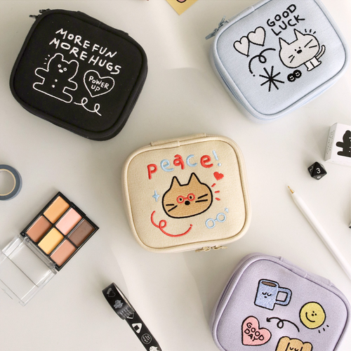 A set of three ICONIC Doodle Mini Pouches in Cream Beige, Lavender, and Sky Blue. Un ensemble de trois mini pochettes ICONIC Doodle en Beige Crème, Lavande et Bleu Ciel.