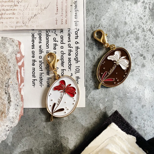 Mr. Eggplants Fondant Flower Metal Key Chain in Caramel and Cream, featuring a gold-plated floral charm on a sturdy circular ring. Porte-clés en métal Fleur de Fondant par Mr. Eggplants, options Caramel et Crème, avec une breloque florale dorée sur un anneau robuste.